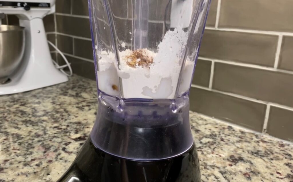 Black and White Blender sitting on countertop with recipe ingredients inside